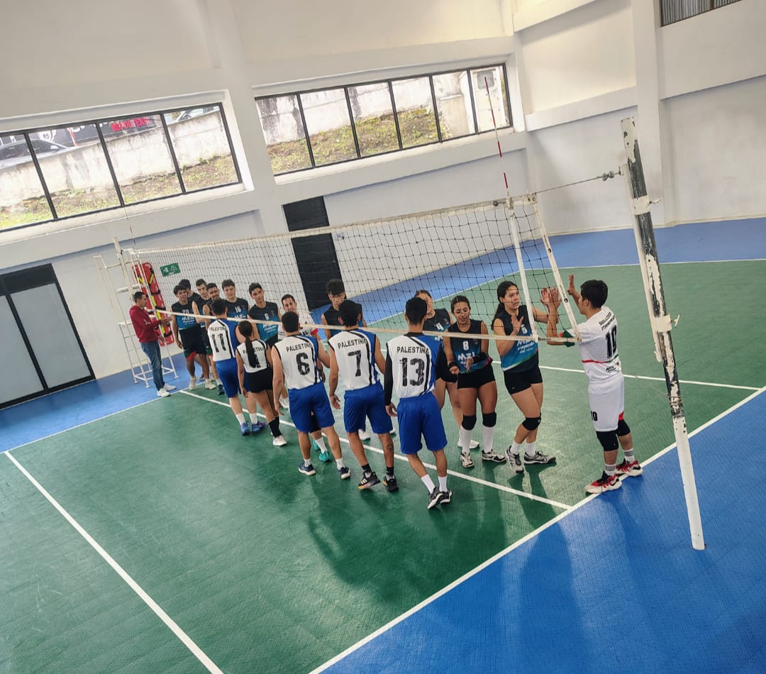 Equipos de voleibol de Palestina y Manizales saludándose en la red durante los Primeros Juegos Metropolitanos en cancha cubierta